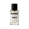 A glass bottle of Scentivia Perfumes 'Aced It' Extrait de Parfum against a black background, featuring a black cap, off-white label, and golden-amber liquid