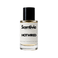 A glass bottle of Scentivia Perfumes 'Hot wired' Extrait de Parfum against a black background, featuring a black cap, off-white label, and golden-amber liquid